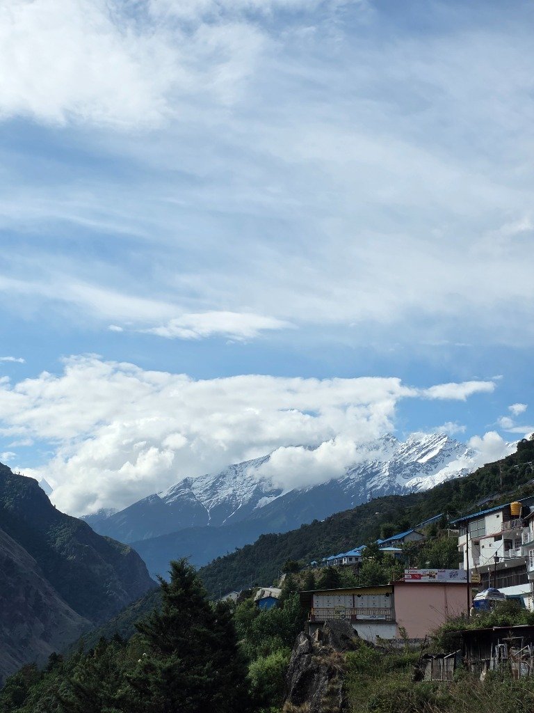 Snow-capped Himalayan peaks towering above local village